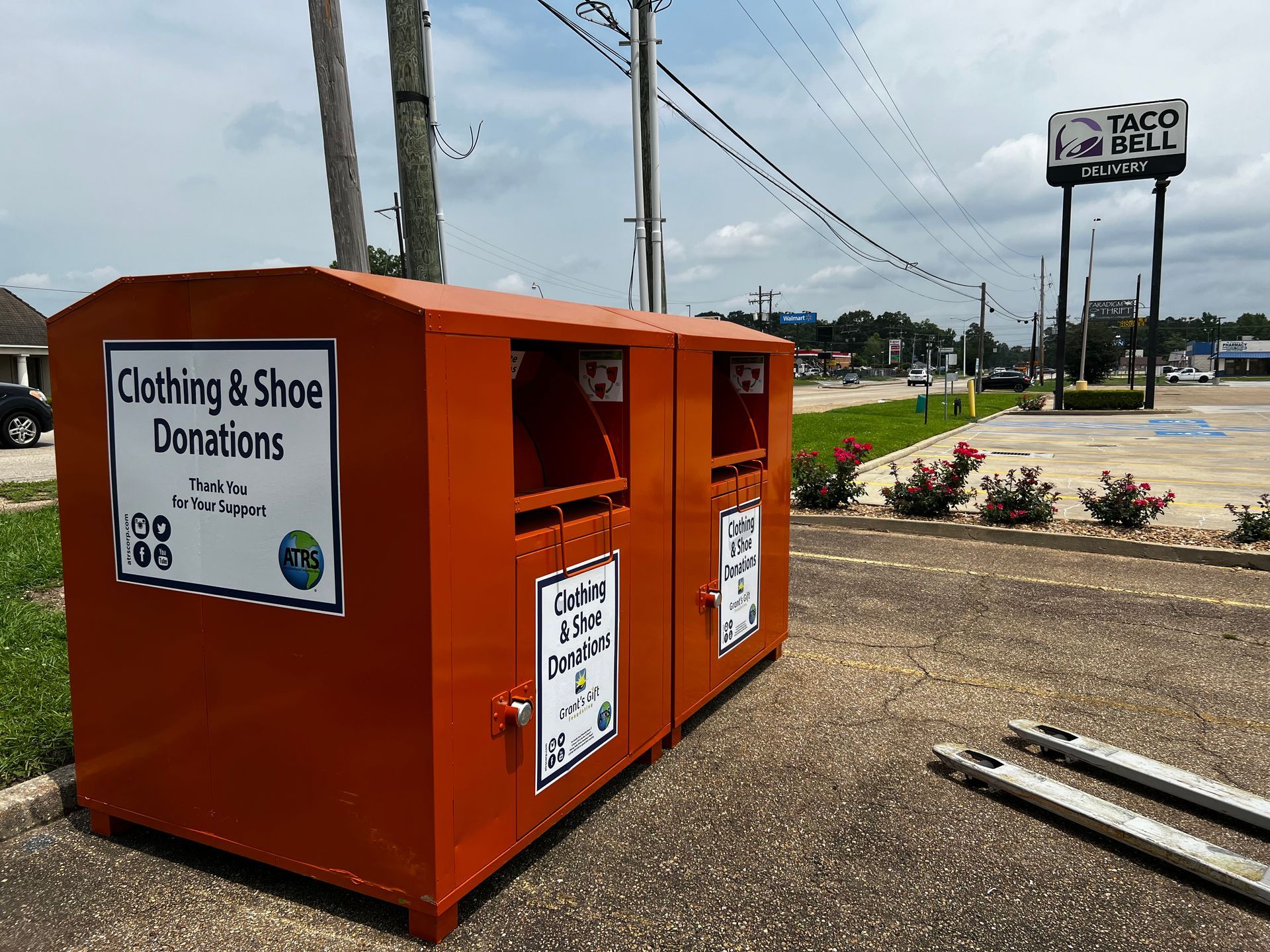 Image of ATRS orange clothing donation bins outside of a retail shopping center.